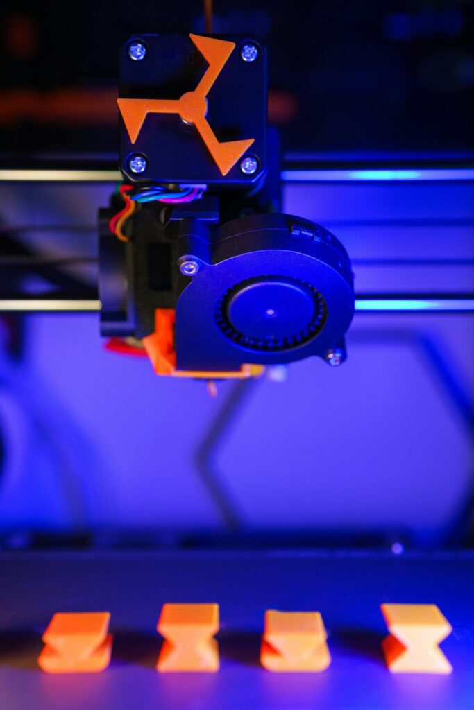 A 3D printer making orange parts